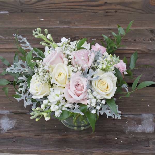 Pink and white roses arranged in a glass vase