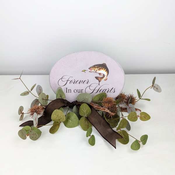 Memorial plaque with eucalyptus and a dark ribbon