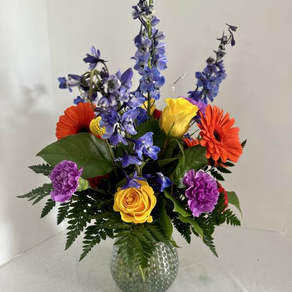Colorful mixed bouquet in a textured glass vase