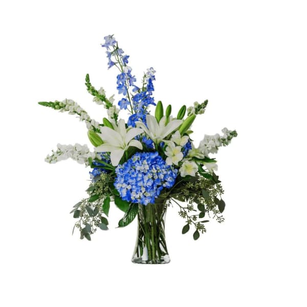 Blue and white floral arrangement in a clear glass vase