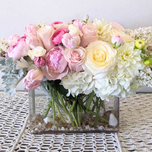 Pink and white flower arrangement in a clear rectangular vase