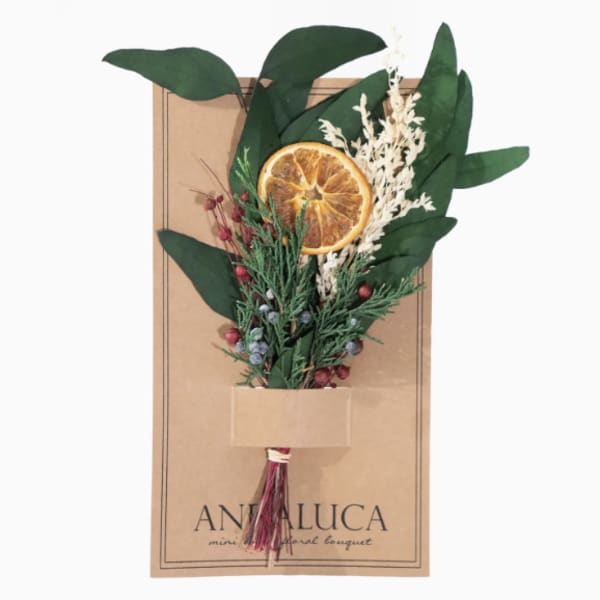 Dried bouquet with an orange slice and greenery on a kraft card
