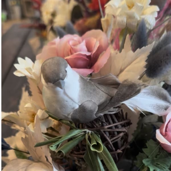 Pink and white floral arrangement with a woven bird nest centerpiece
