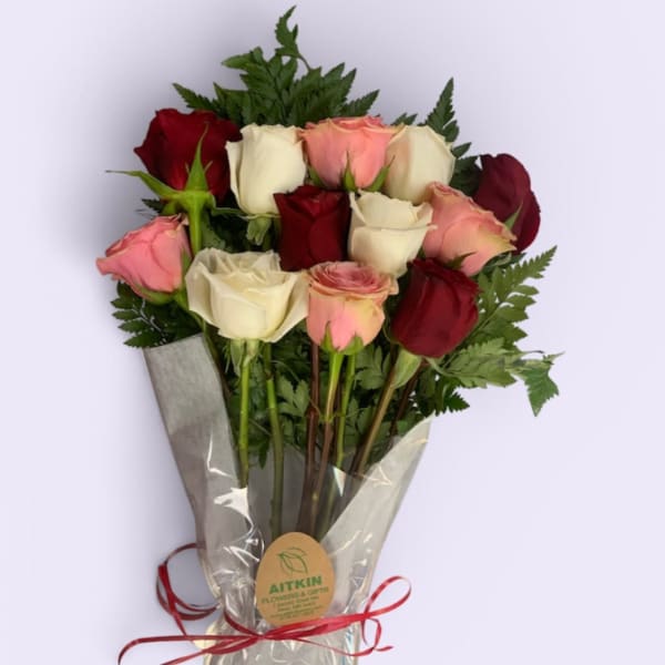 Bouquet of red, pink, and white roses wrapped in clear plastic