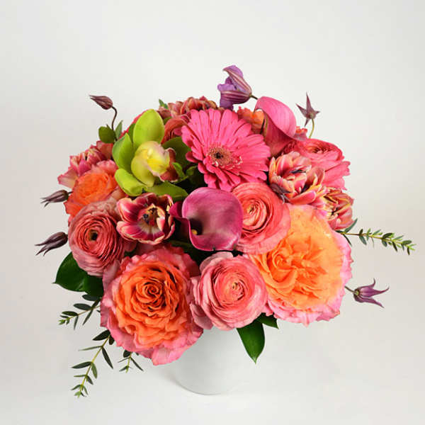 Pink and orange mixed bouquet in a white vase
