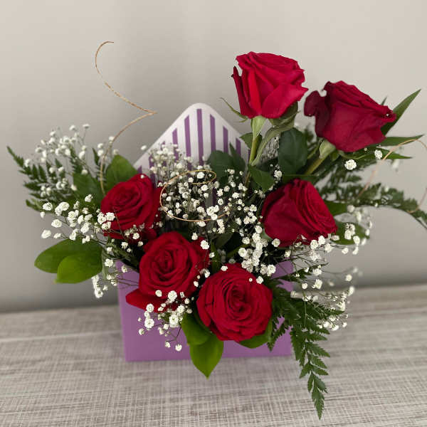 Bouquet of red roses with baby's breath in a purple gift box