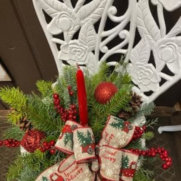 Christmas arrangement with pine, red berries, and a red candle