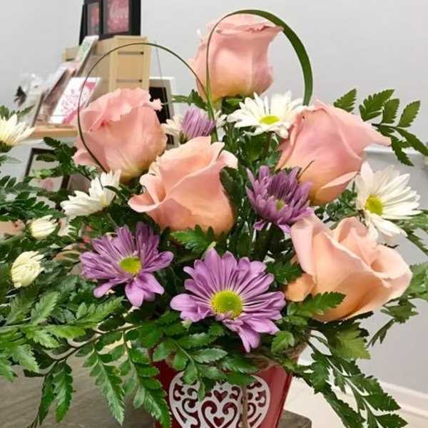 Pink roses and purple daisies in a red heart-decorated basket