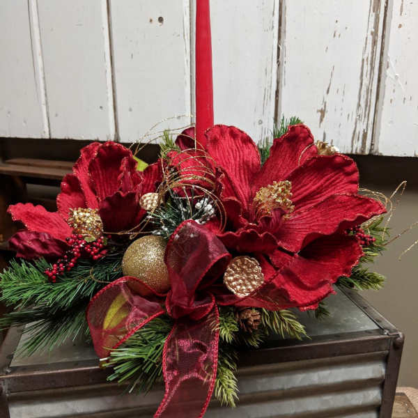 Red floral centerpiece with a tall candle in a metal container
