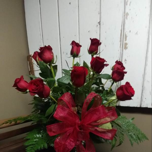 Bouquet of red roses with a large red ribbon in a glass vase