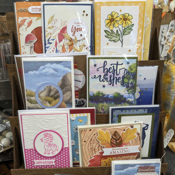 Display rack of handmade greeting cards with floral and birthday designs