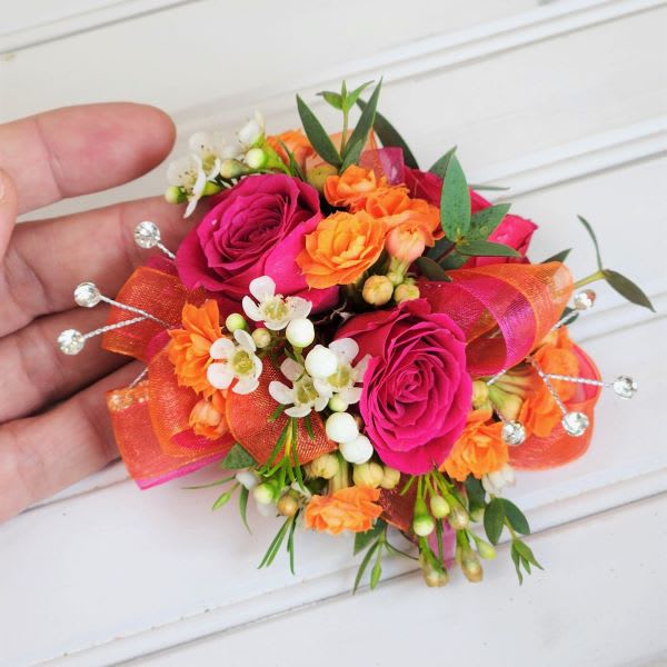 Small wrist corsage with pink roses and orange flowers