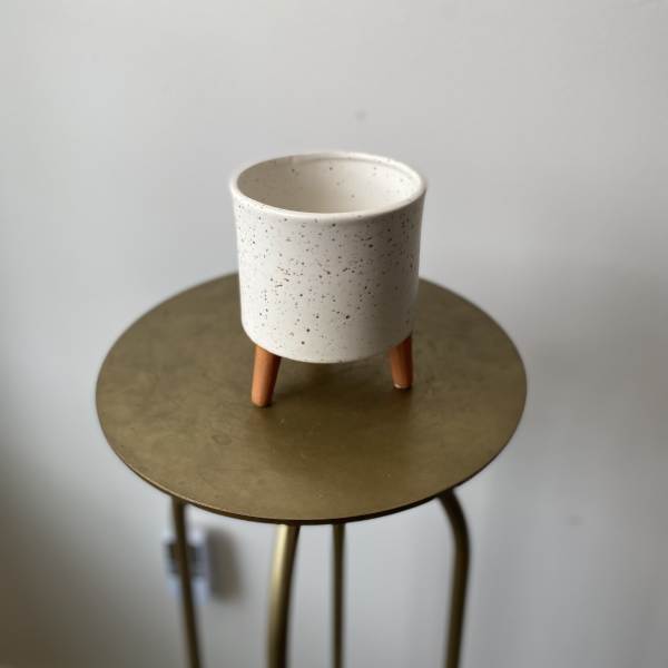 Speckled white ceramic planter on a small stand