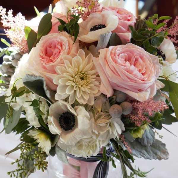 Pink and white bouquet in a glass vase with ribbon