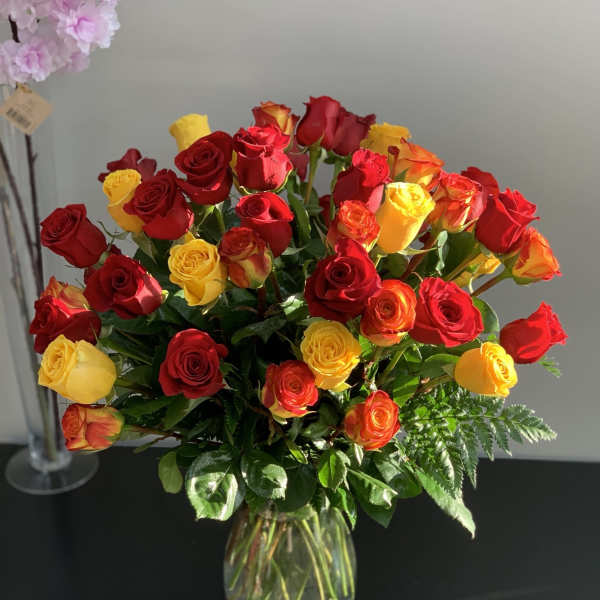 Bouquet of red and yellow roses in a clear glass vase