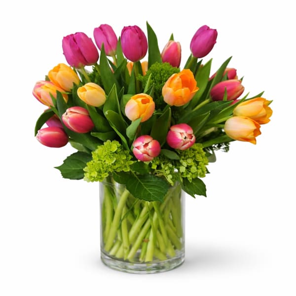 Bouquet of pink and orange tulips in a clear glass vase