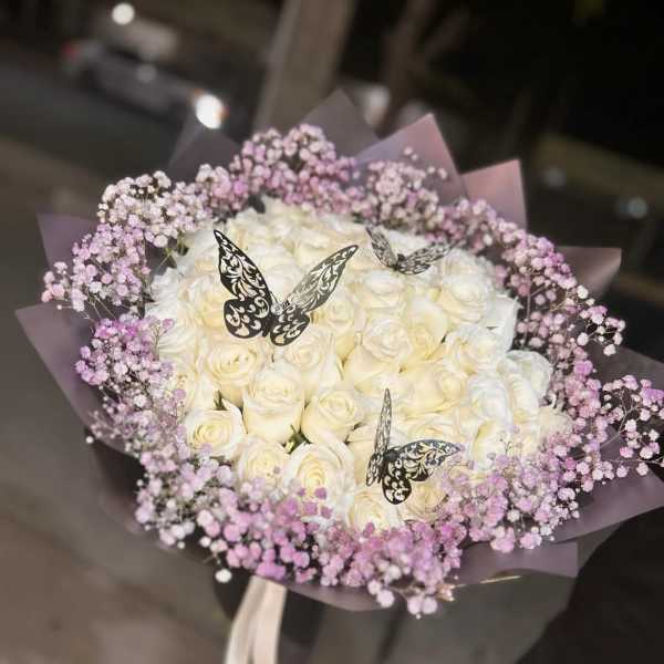 Bouquet of white roses with pink baby's breath and butterfly picks