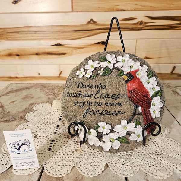 Decorative memorial plaque with white flowers and a red cardinal