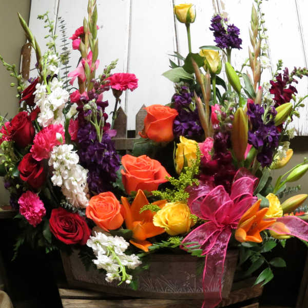 Colorful mixed flower arrangement in a wooden container