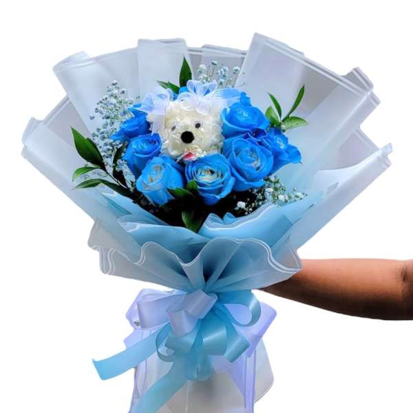 Blue rose bouquet with a small teddy bear center and ribbon wrap