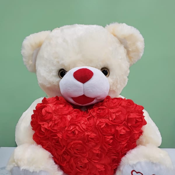 White teddy bear holding a red heart
