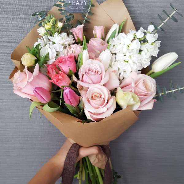 Hand-tied bouquet of pink and white roses with tulips and white blooms