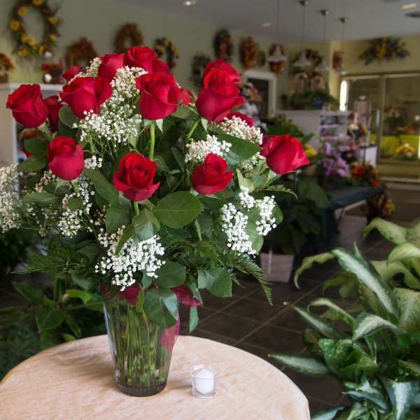 Bouquet of red roses and baby's breath in a clear glass vase