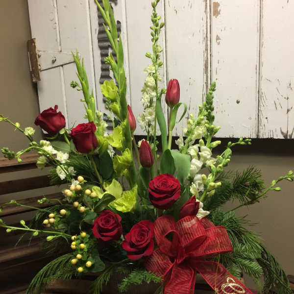 Red roses and green snapdragons in a low arrangement with a red ribbon