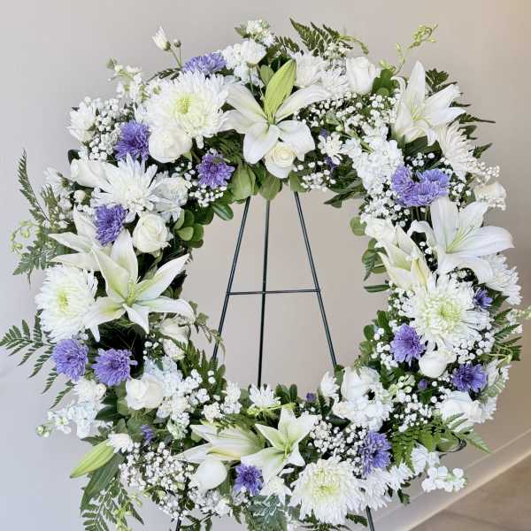 White and lavender floral wreath on a metal stand