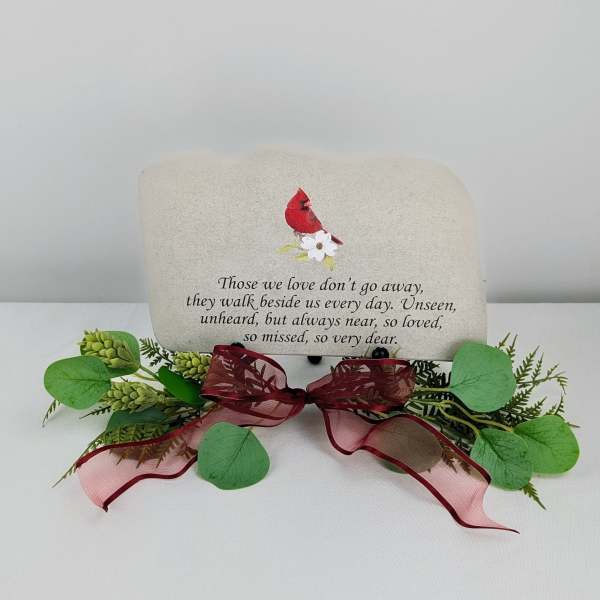 Memorial stone with a red cardinal and floral decoration