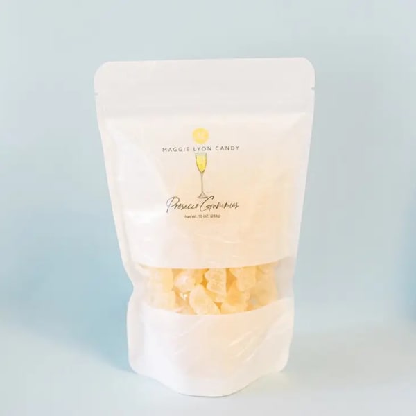 White pouch of prosecco gummies on a pale blue background