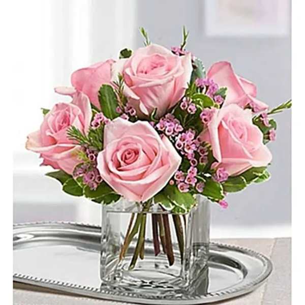 Pink roses arranged in a clear glass vase