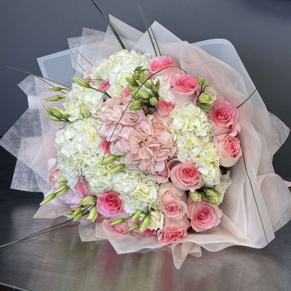 Pink roses and white hydrangeas in pale wrapping