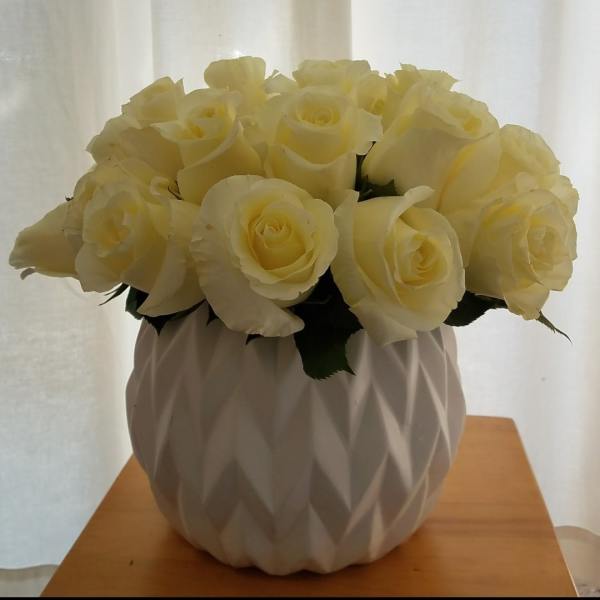 Cream rose bouquet in a white textured vase