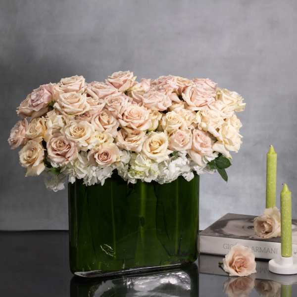 Blush roses and white hydrangeas in a green glass vase