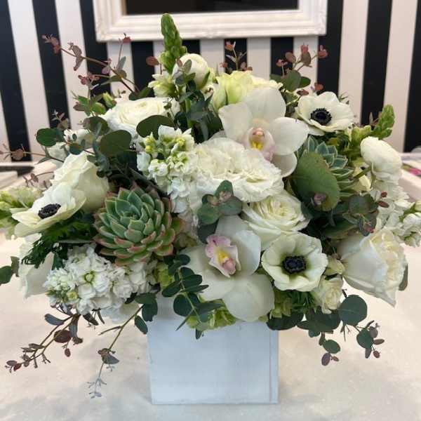 White floral arrangement with succulents in a white box