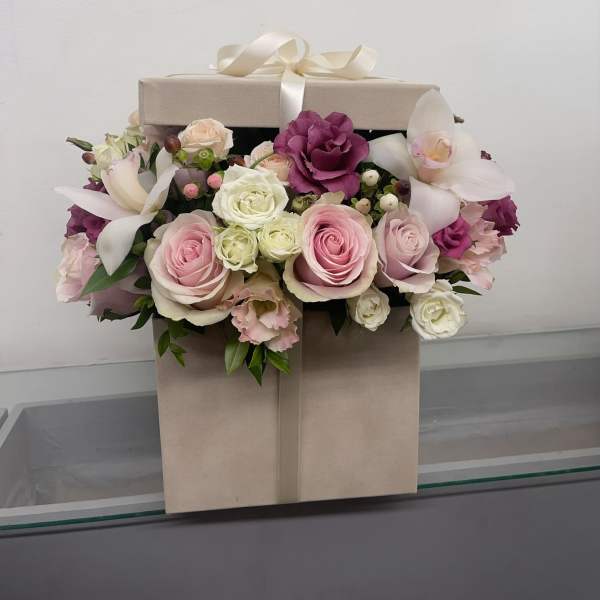Pink and white roses with orchids in a beige gift box