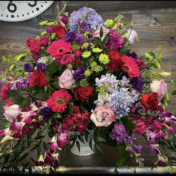 Large mixed bouquet with roses, gerbera daisies, hydrangeas, and orchids in a vase