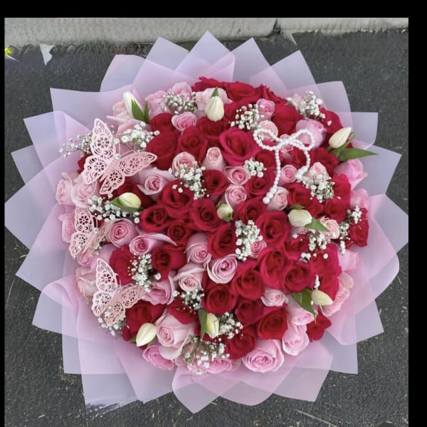 Large bouquet of pink and red roses with butterfly decorations
