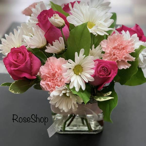 Pink roses and white daisies in a glass vase