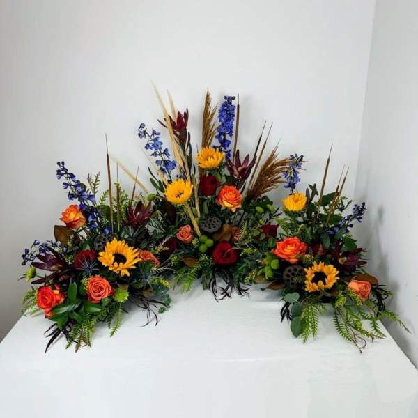 Colorful floral casket spray with roses and sunflowers