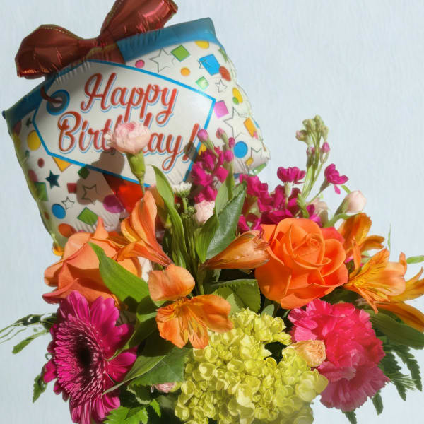 Birthday bouquet with a foil balloon in a glass vase