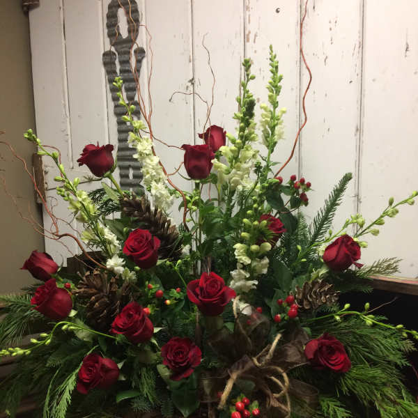 Red roses and white snapdragons in a rustic holiday arrangement