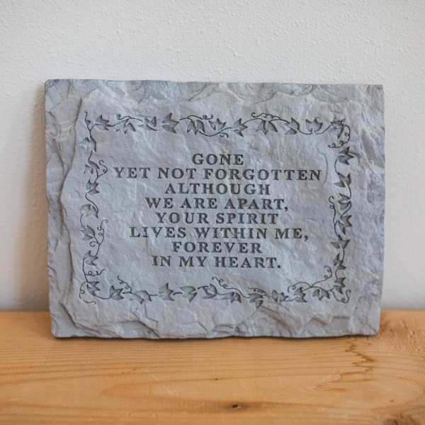 Stone memorial plaque with an engraved remembrance message