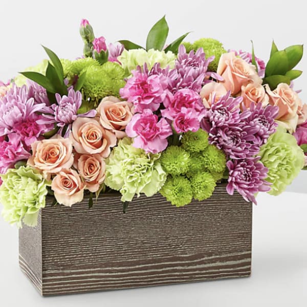 Mixed pink and green flower arrangement in a wooden box