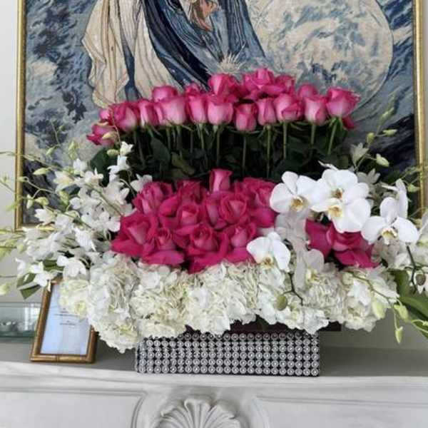Pink roses and white orchids arranged in a decorative box