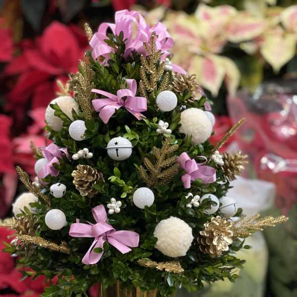 Small decorated evergreen tree in a gold pot with pink ribbons and ornaments