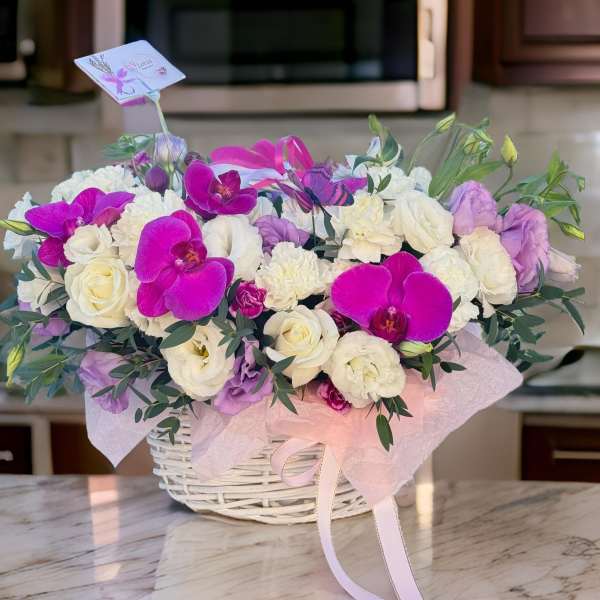 Basket of white and purple flowers with pink orchids
