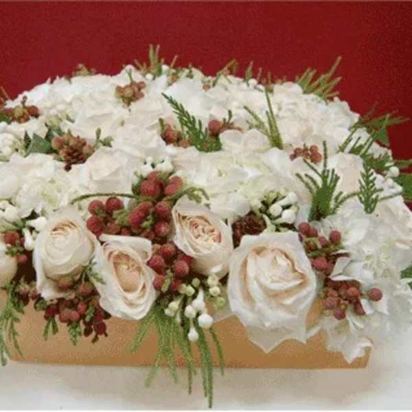 White rose arrangement in a rectangular box with red berries