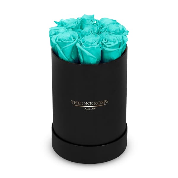 Turquoise roses arranged in a black round box